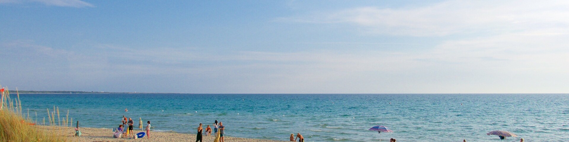 Baia Verde Beach showing a sandy beach and general coastal views as well as a large group of people
