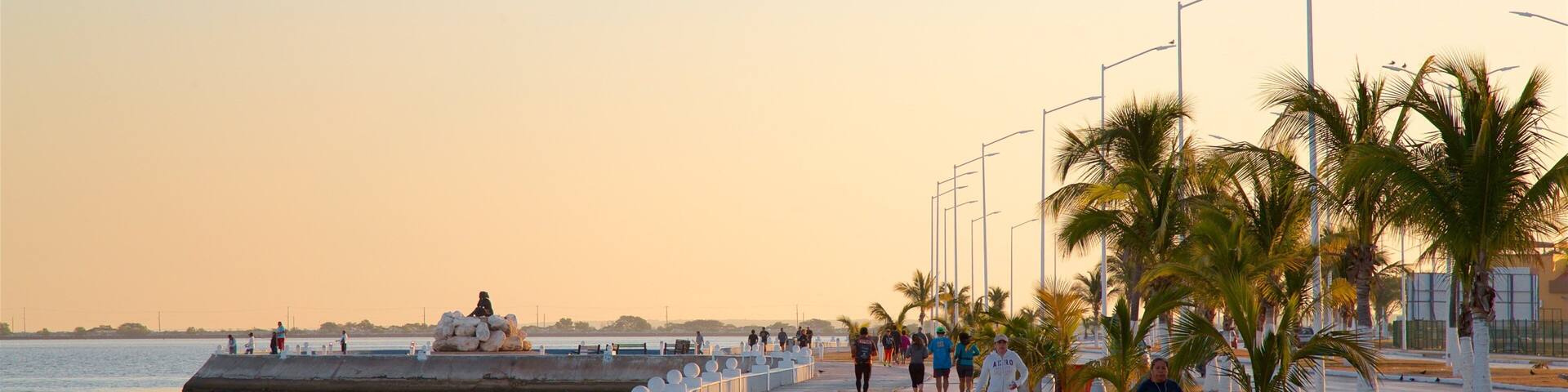 Campeche Waterfront Promenade which includes a sunset, a bay or harbour and hiking or walking