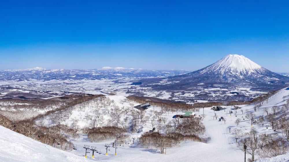 Panorama view of snowy volcano and slopes on a clear day in early spring (Niseko Mt.Resort Grand Hirafu, Hokkaido, Japan)