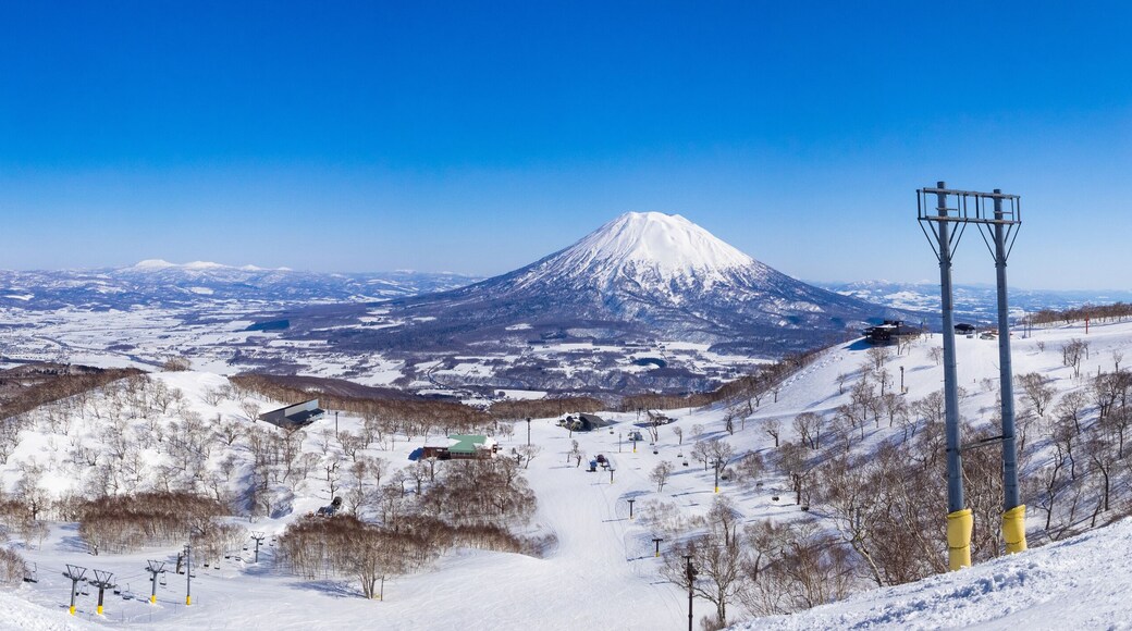 Panorama view of snowy volcano and slopes on a clear day in early spring (Niseko Mt.Resort Grand Hirafu, Hokkaido, Japan)
