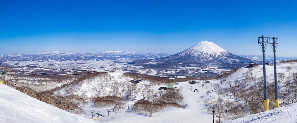 Panorama view of snowy volcano and slopes on a clear day in early spring (Niseko Mt.Resort Grand Hirafu, Hokkaido, Japan)