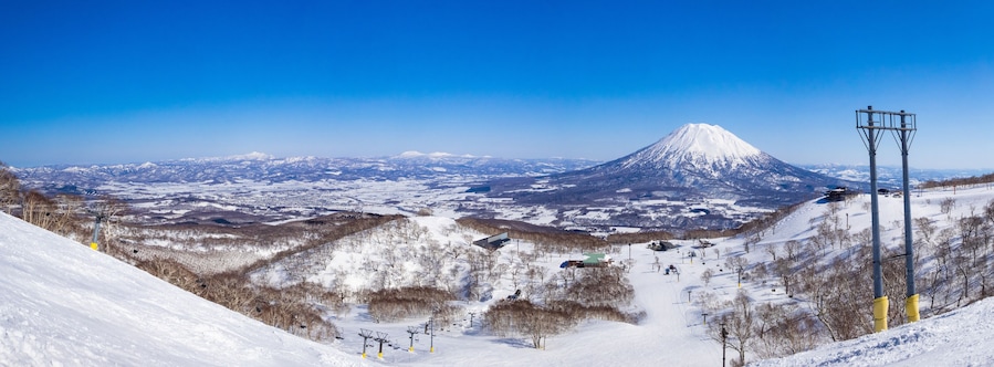 Panorama view of snowy volcano and slopes on a clear day in early spring (Niseko Mt.Resort Grand Hirafu, Hokkaido, Japan)