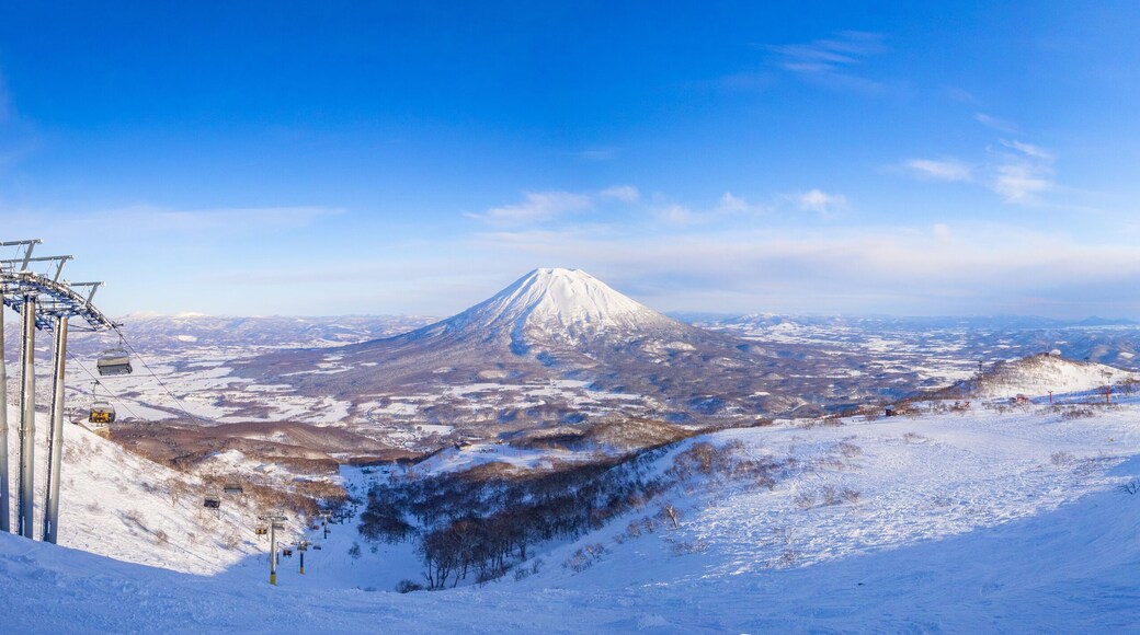 Skiers seeing a snowy volcano in late afternoon (Niseko, Hokkaido, Japan)