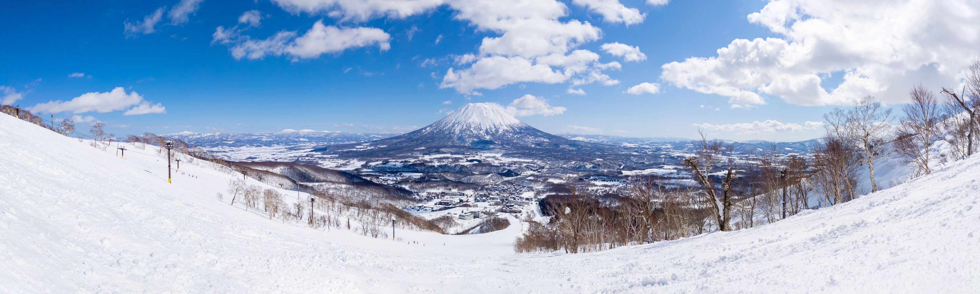 Panoramic view of snowy volcano and town seen from a ski resort (Niseko, Hokkaido, Japan)