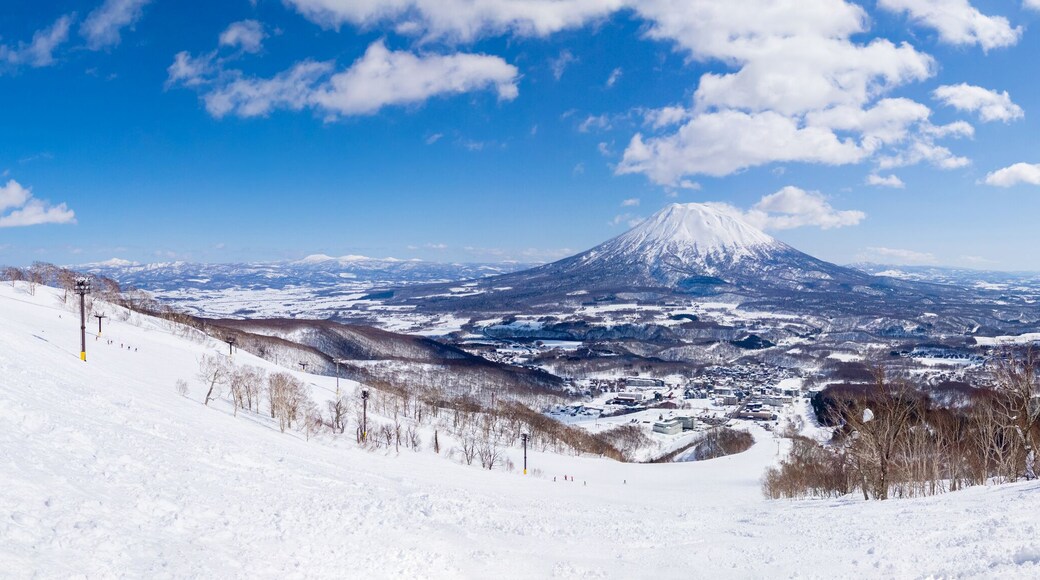 Panoramic view of snowy volcano and town seen from a ski resort (Niseko, Hokkaido, Japan)
