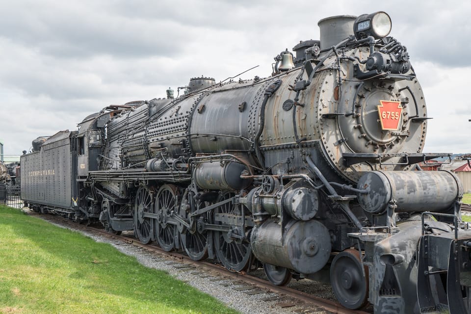 Una locomotora de vapor antigua y grande con el número 6755 sobre una vía férrea.