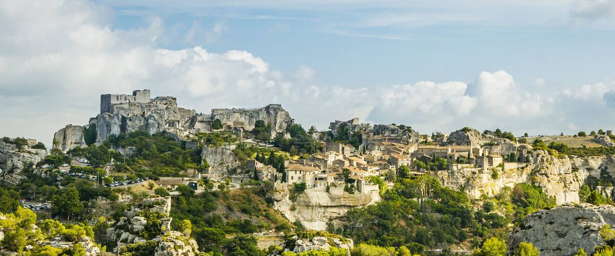 A historic fortified town perched on rocky cliffs with lush greenery.