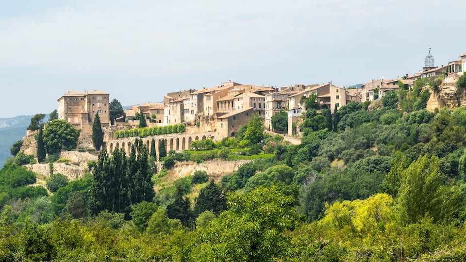 A hillside village with terraced buildings and a prominent tower.