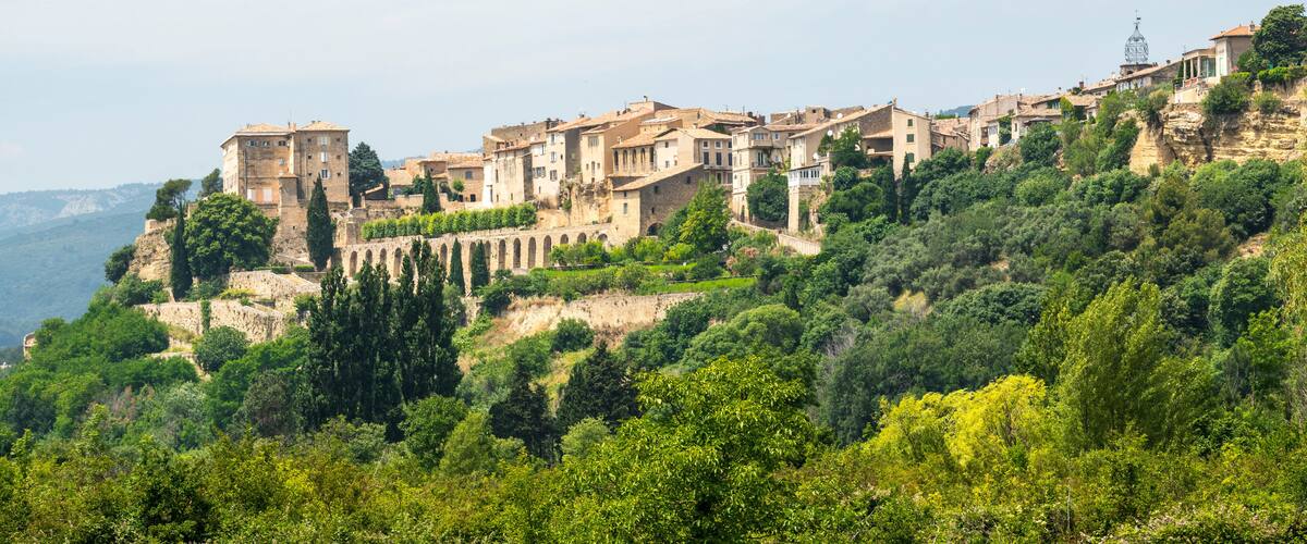 A hillside village with terraced buildings and a prominent tower.