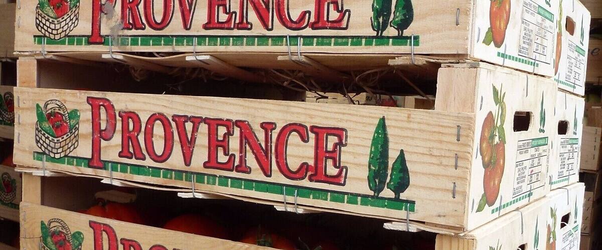A stack of wooden crates labeled 'PROVENCE' with illustrations of tomatoes and green leaves.