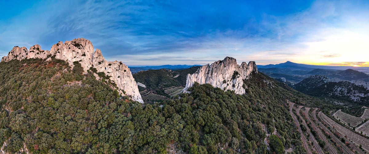 A mountainous landscape with rugged cliffs and terraced fields.