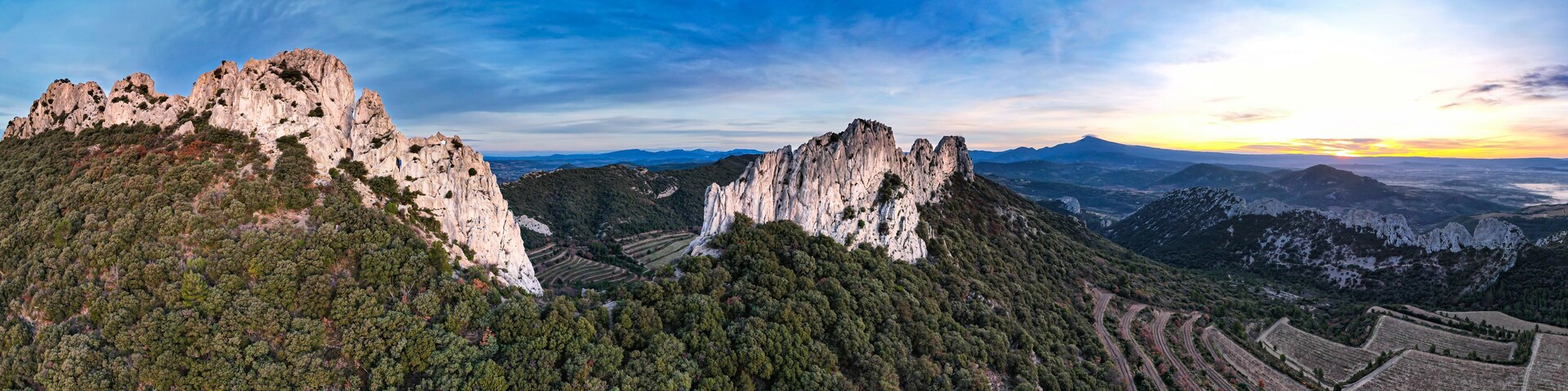 A mountainous landscape with rugged cliffs and terraced fields.