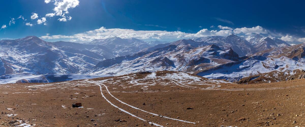 A mountainous landscape with snow-covered peaks and a clear sky.