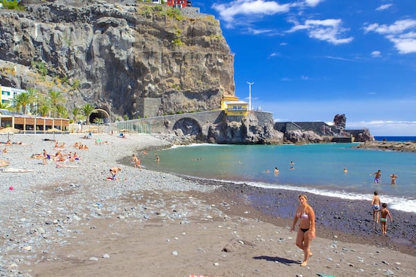 Ponta Do Sol Beach featuring swimming, a coastal town and a pebble beach