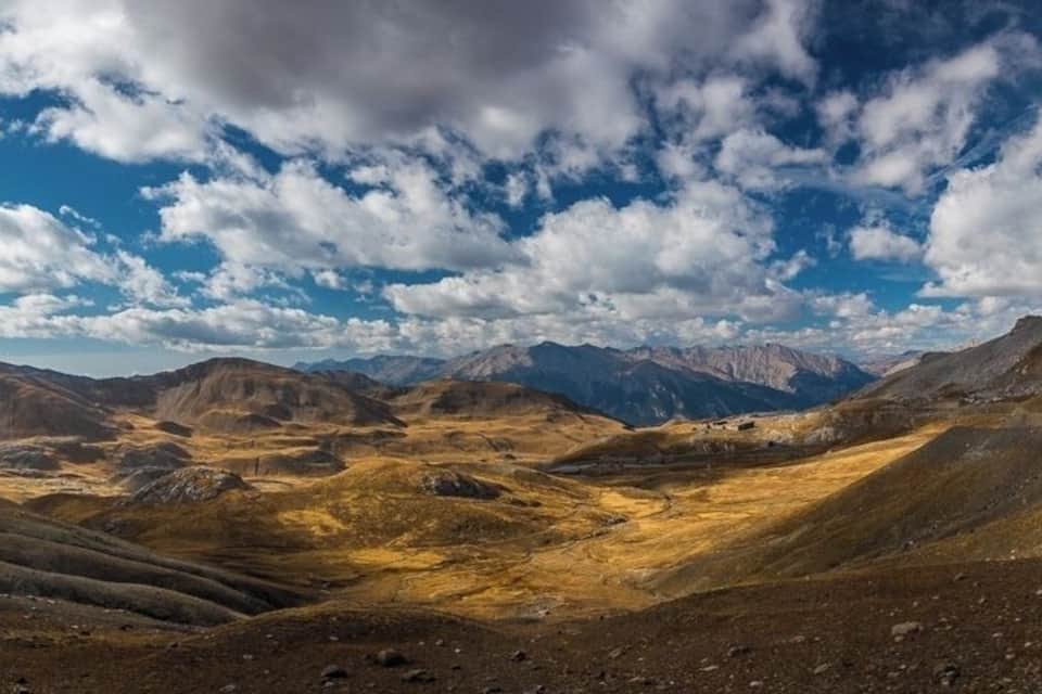 A mountainous landscape with rolling hills and a clear sky.
