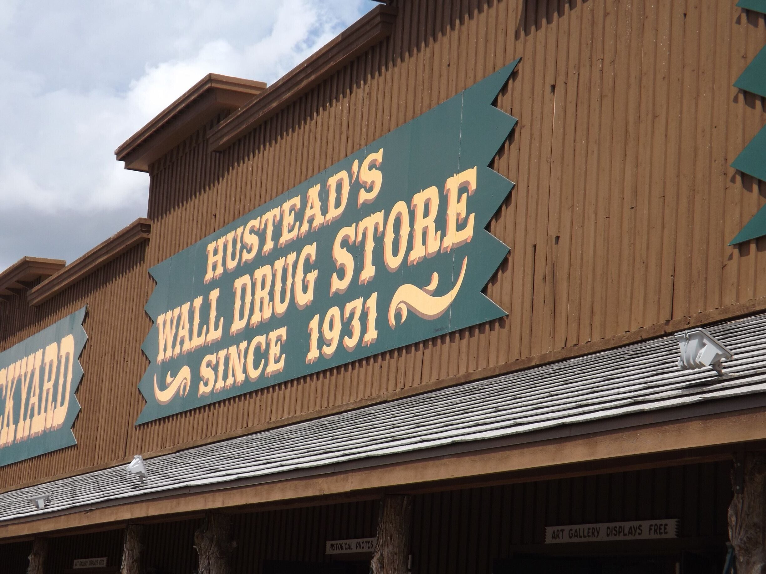 A storefront with a sign reading "Hustead's Wall Drug Store Since 1931".