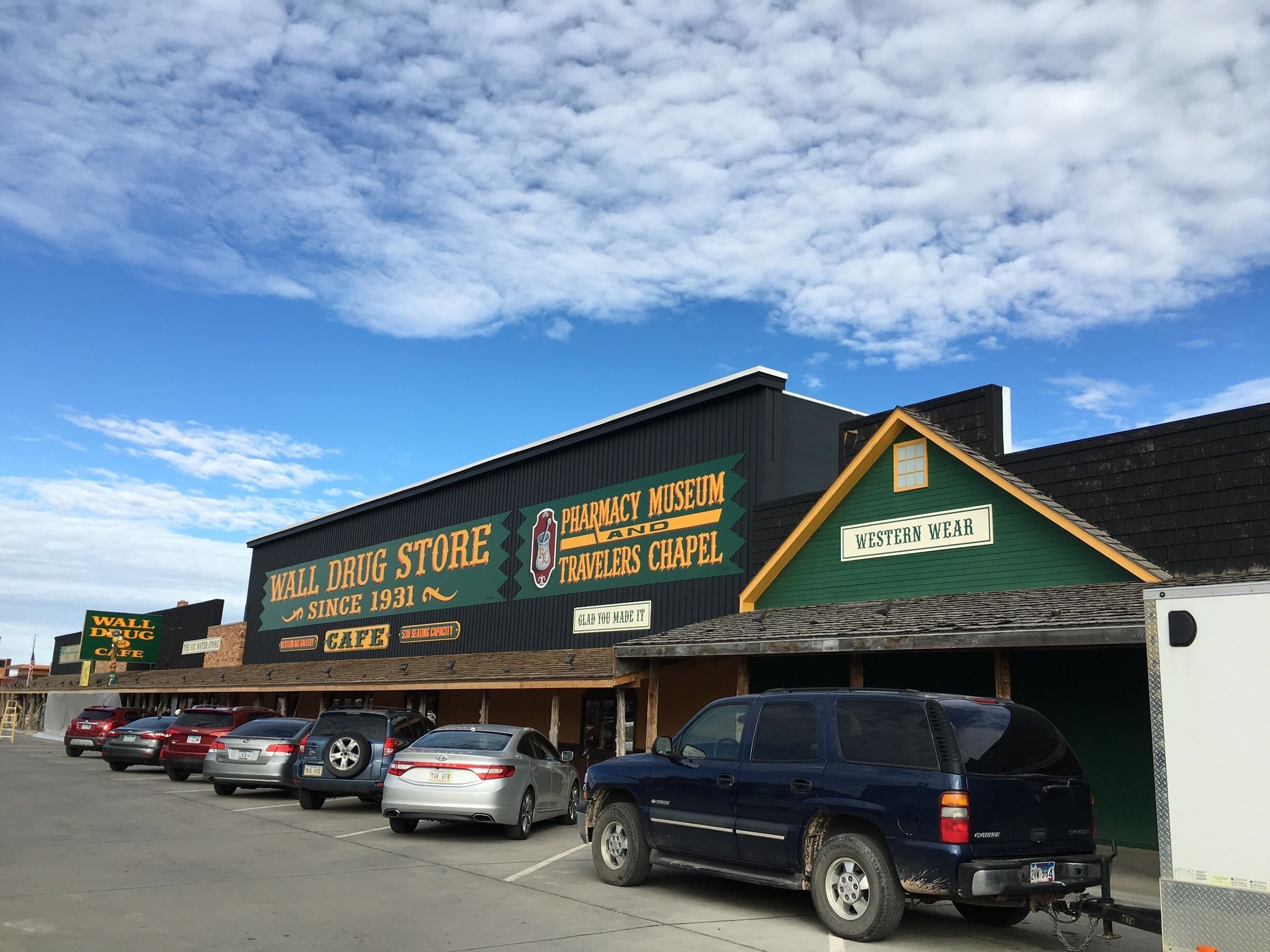 A building with signs for a pharmacy museum, travelers chapel, and a wall drug store.