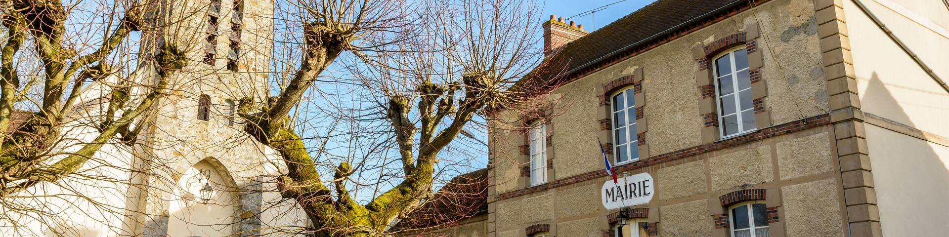The church square of the small french village of Beauvoir in the department of Seine-et-Marne, 60 kilometers south-east to Paris, with its town hall, church and elementary school in between at sunset.