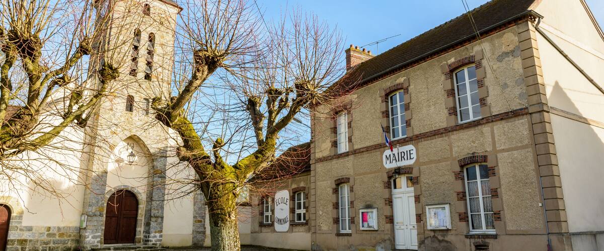 A historic building with a tower and a sign that reads "MAIRIE".