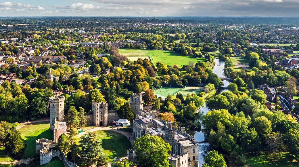 A castle surrounded by lush greenery and a river.