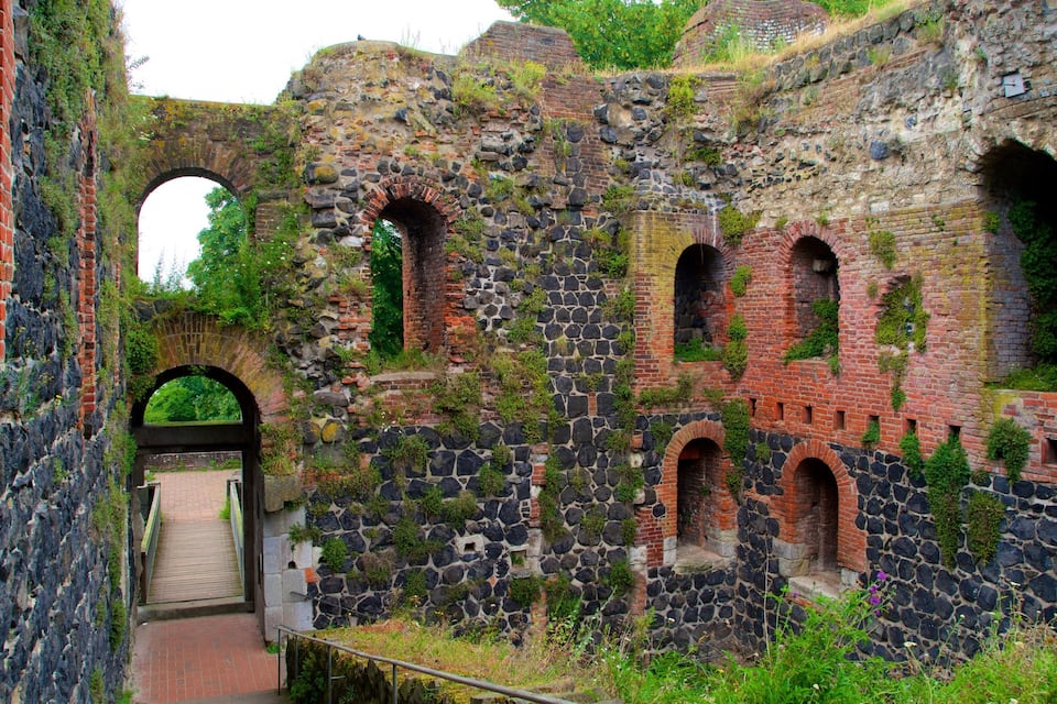An ancient stone and brick structure with arched passageways and a wooden gate.