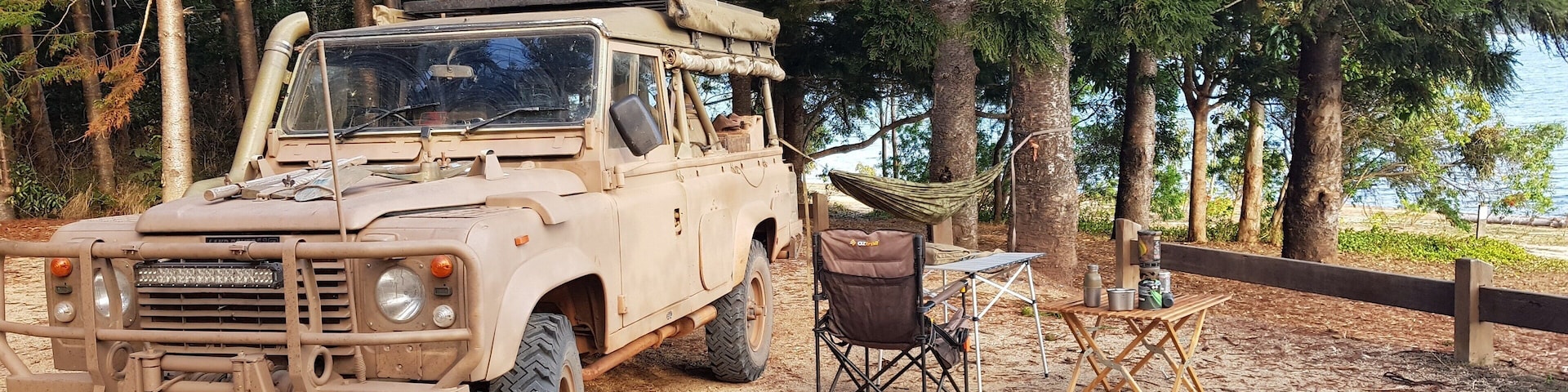 A simple setup at Platypus on the shores of Lake Tinaroo near Tolga on Queensland's Atherton Tablelands. A chair and two camp tables as combination camp kitchen and office, then a hammock tied between the Landy's roll bar and a big old beautiful kauri pine tree - a work of art with the backdrop of Lake Tinaroo as the canvas.