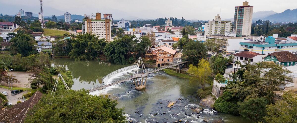 A river with a bridge, surrounded by buildings and greenery.