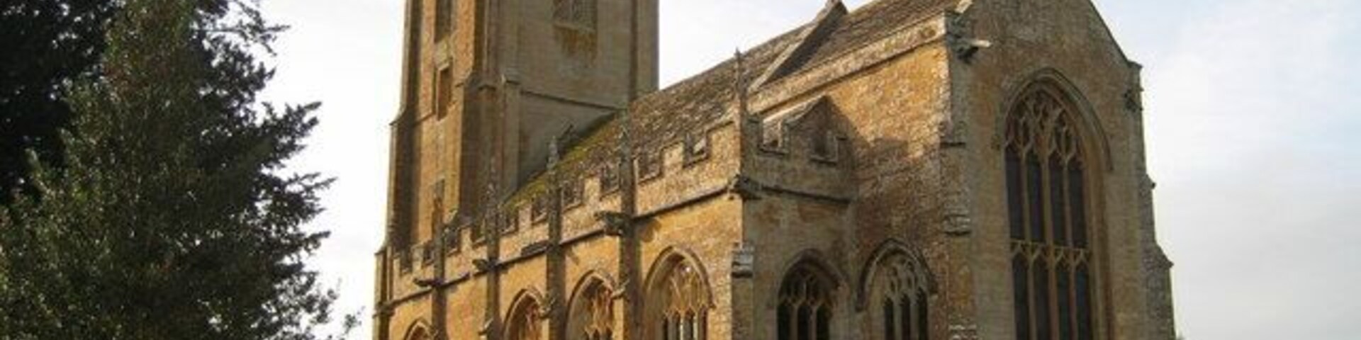 Uma igreja histórica com uma torre alta e janelas em arco.