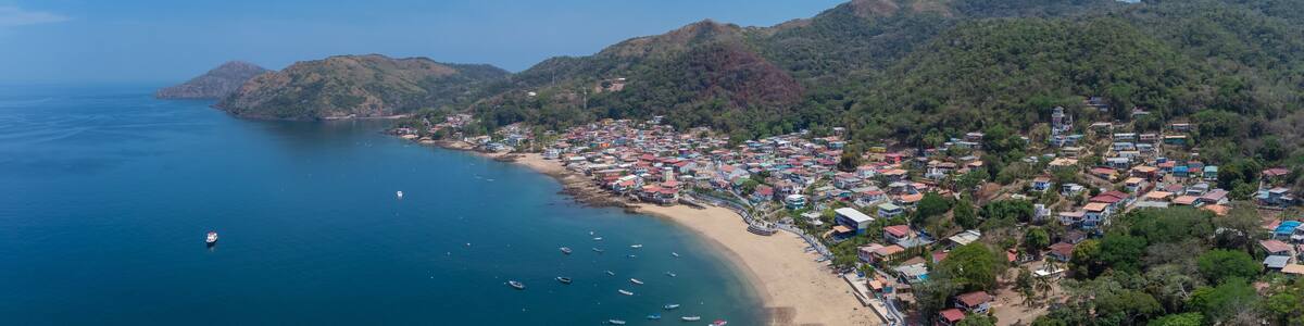 Aerial drone panorama of the village and island of Taboga, popular getaway spot close to Panama city. Visible village, houses and hills in the background.
