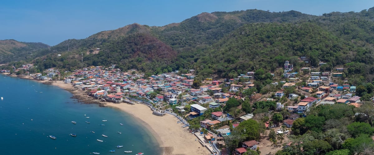 Aerial drone panorama of the village and island of Taboga, popular getaway spot close to Panama city. Visible village, houses and hills in the background.