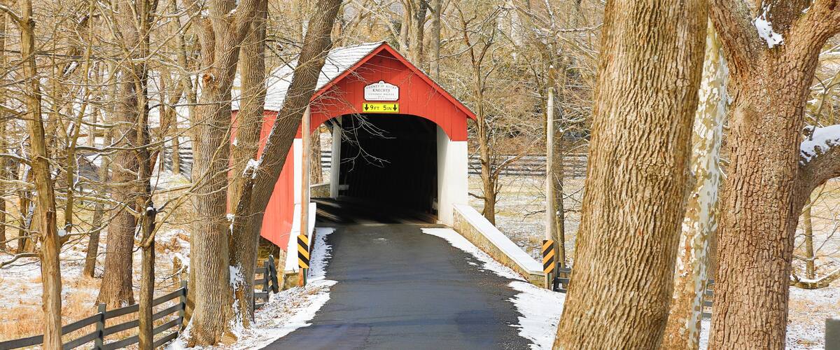 A red covered bridge with a sign indicating '9ft 5in' clearance.