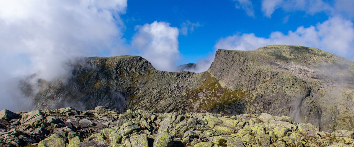 Rugged mountains with rocky terrain and patches of greenery.