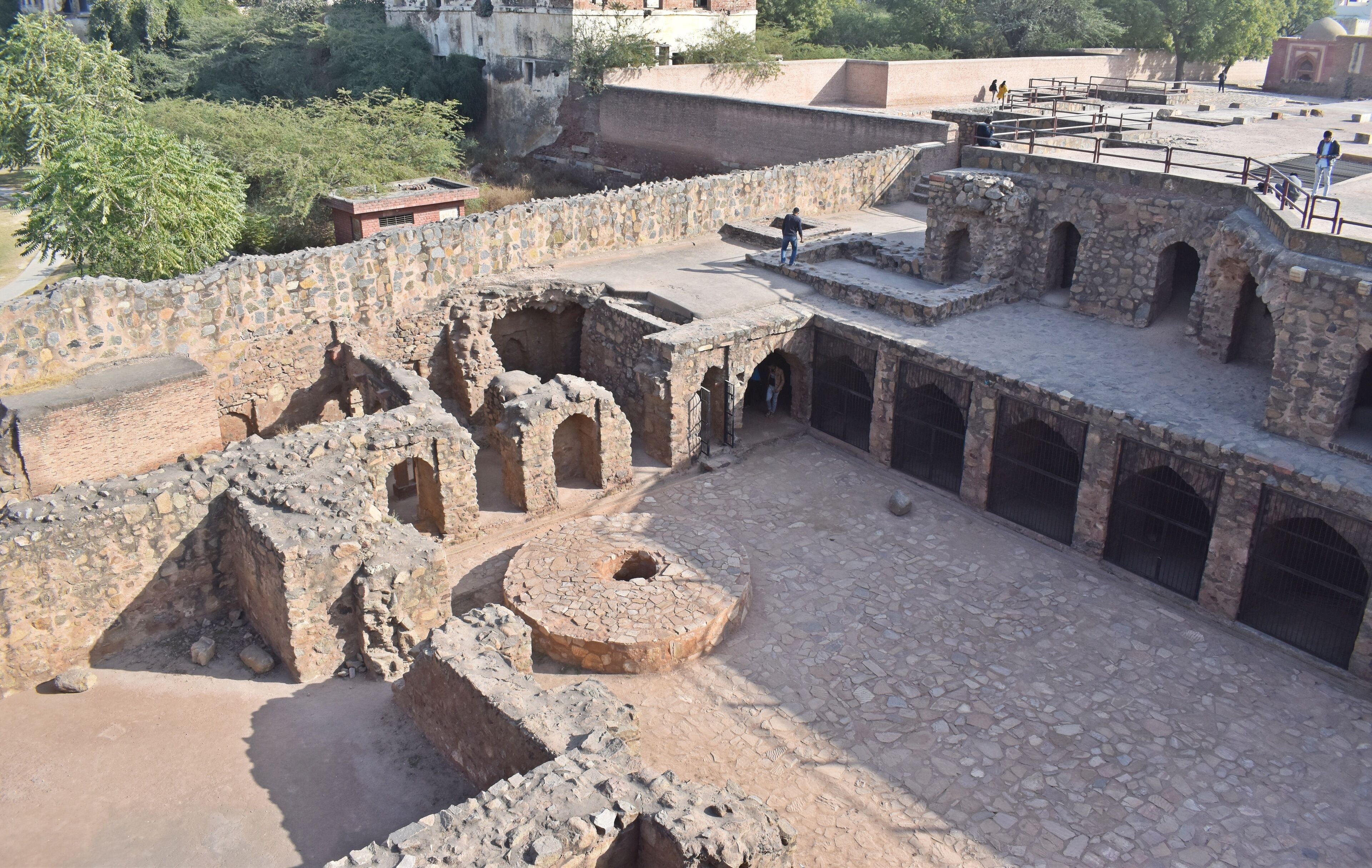 An ancient stone structure with arched passageways and a central courtyard.