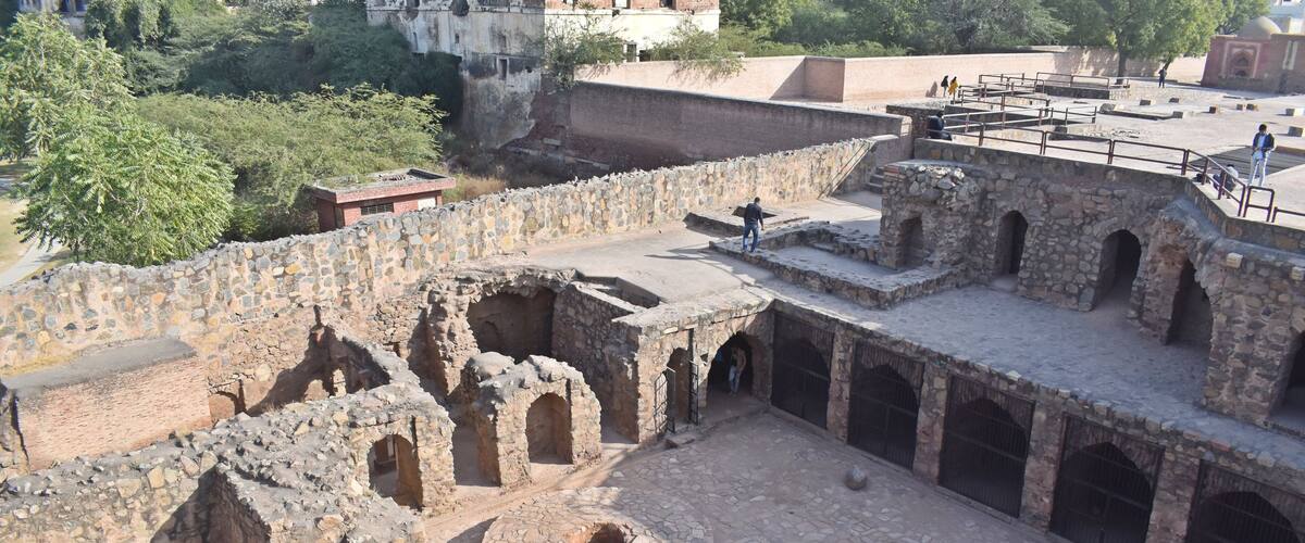 An ancient stone structure with arched passageways and a central courtyard.