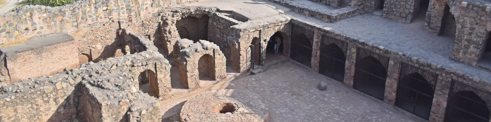 An ancient stone structure with arched passageways and a central courtyard.