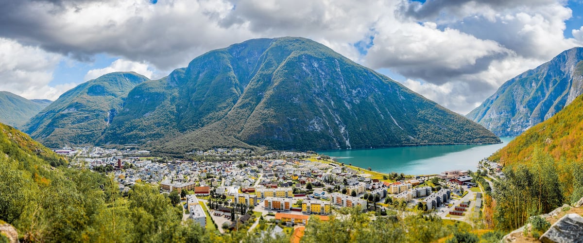 A town nestled between mountains with a lake in the background.