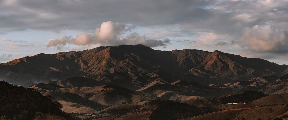 A mountain range with rugged terrain and a winding road.