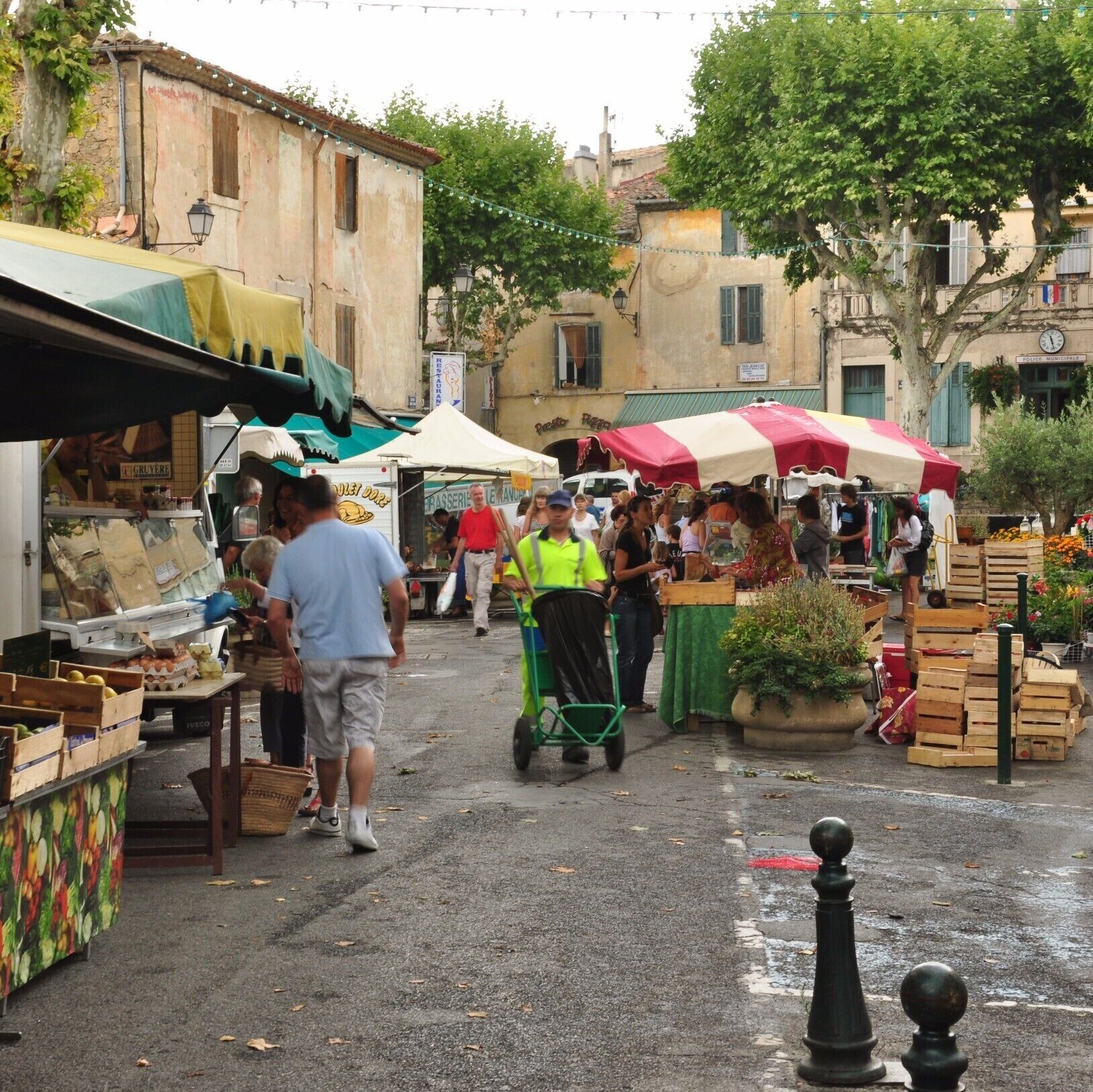 A bustling outdoor market with vendors and shoppers.
