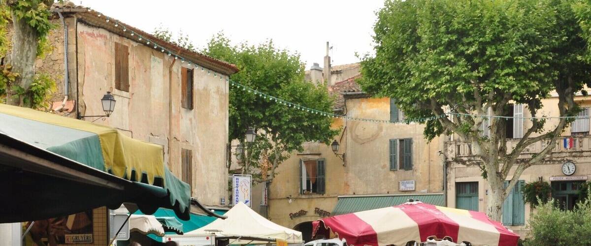 A bustling outdoor market with vendors and shoppers.