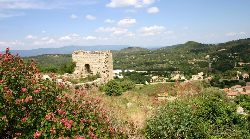 Une tour de pierre se dressant au milieu d’une végétation luxuriante et de collines ondoyantes.