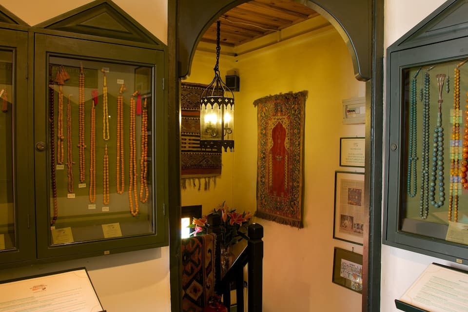 A display of various beaded necklaces in a museum.