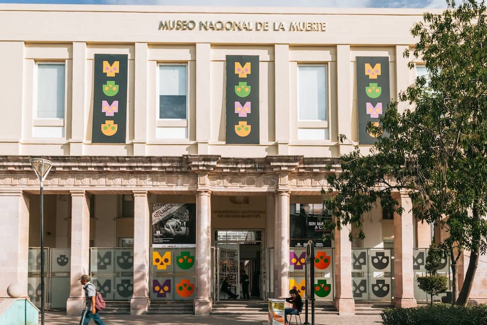 El edificio del Museo Nacional de la Muerte, con columnas y pancartas.