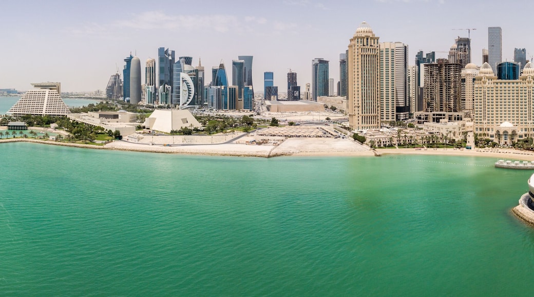 The skyline of Doha, Qatar. Modern rich middle eastern city of skyscrapers, aerial view in good weather, midday, during hot dry summer, with view of marina and beach of Persian Gulf/Arabian Gulf