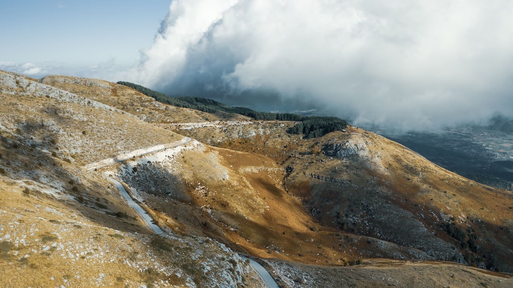 Aerial view of Pangaio mountain landscape with road and thick clouds at daytime.