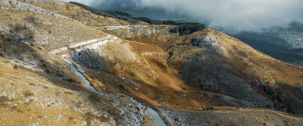 Aerial view of Pangaio mountain landscape with road and thick clouds at daytime.