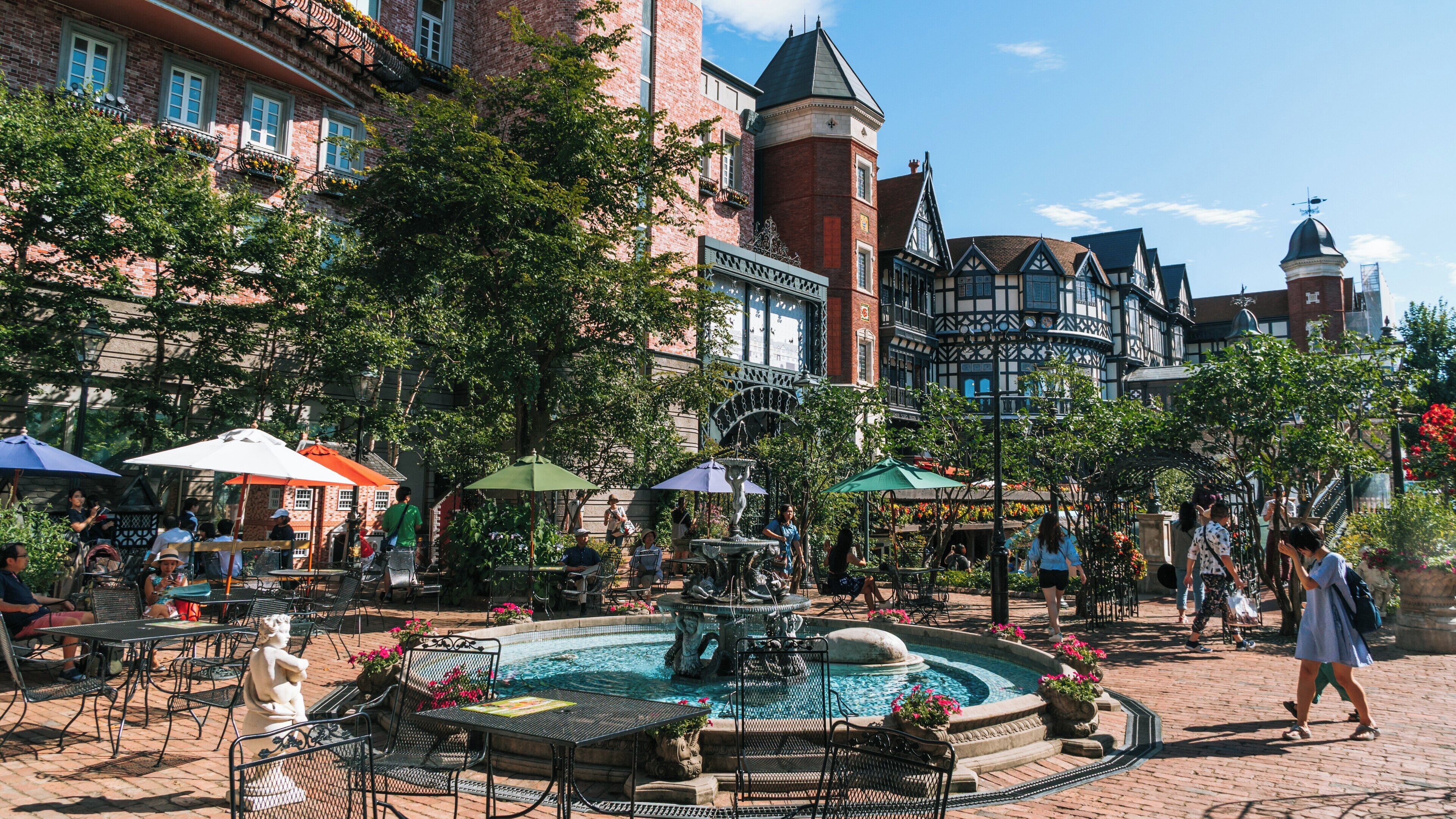 Visitors enjoy a sunny day at Shiroi Koibito Park in Sapporo, Hokkaido, surrounded by charming architecture and vibrant greenery
