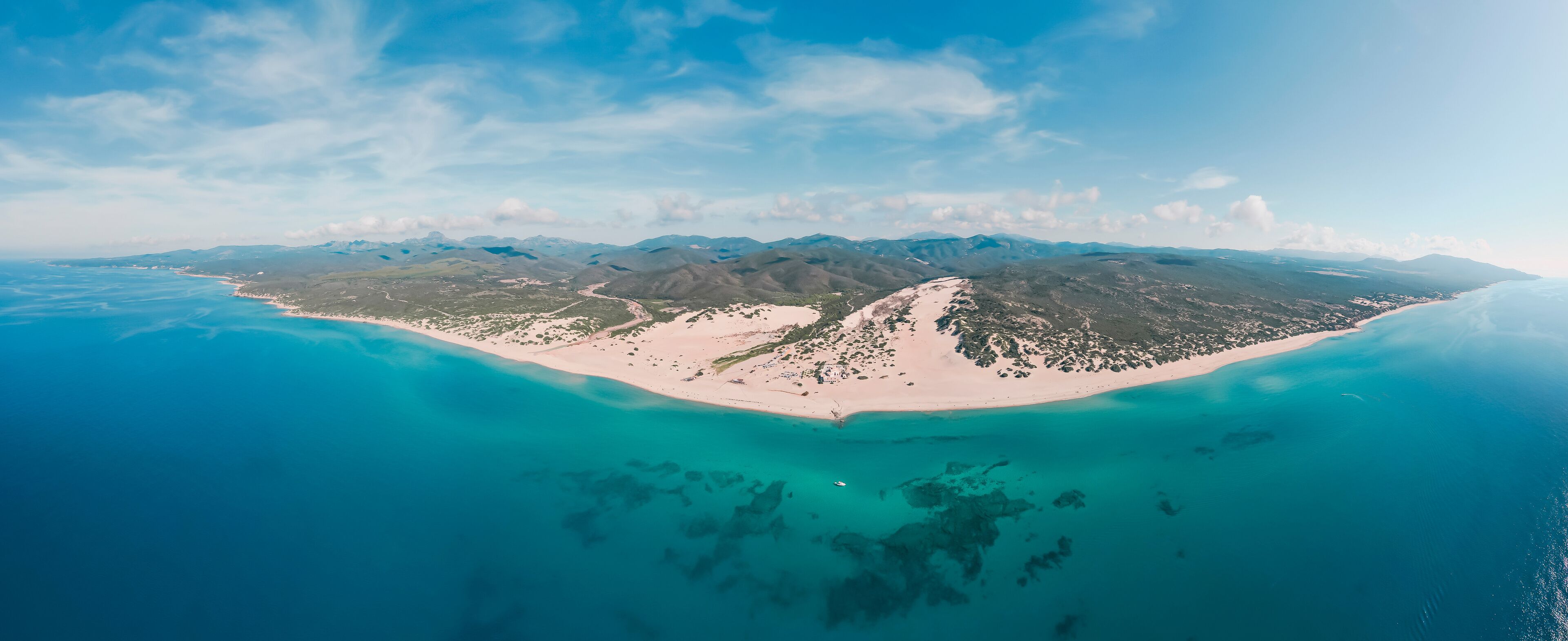 Aerial panoramic view of sand dunes along the coastline at Piscinas Beach, Arbus, Sardinia, Italy.