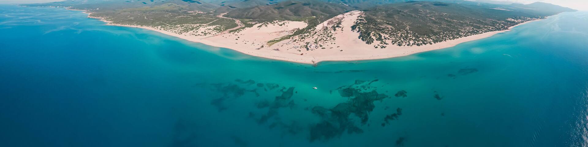 Aerial panoramic view of sand dunes along the coastline at Piscinas Beach, Arbus, Sardinia, Italy.