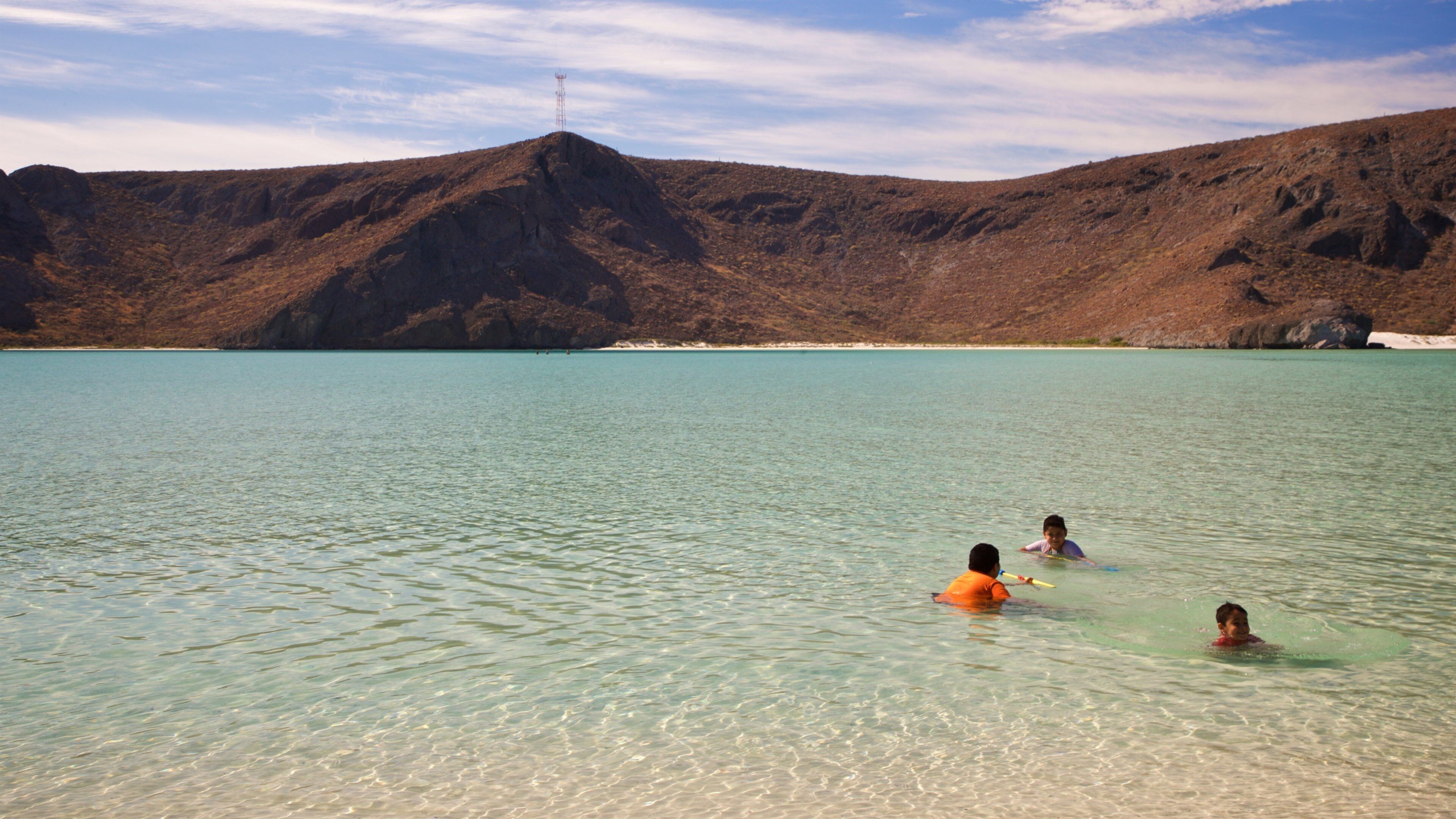 Balandra Beach featuring swimming and general coastal views as well as a small group of people