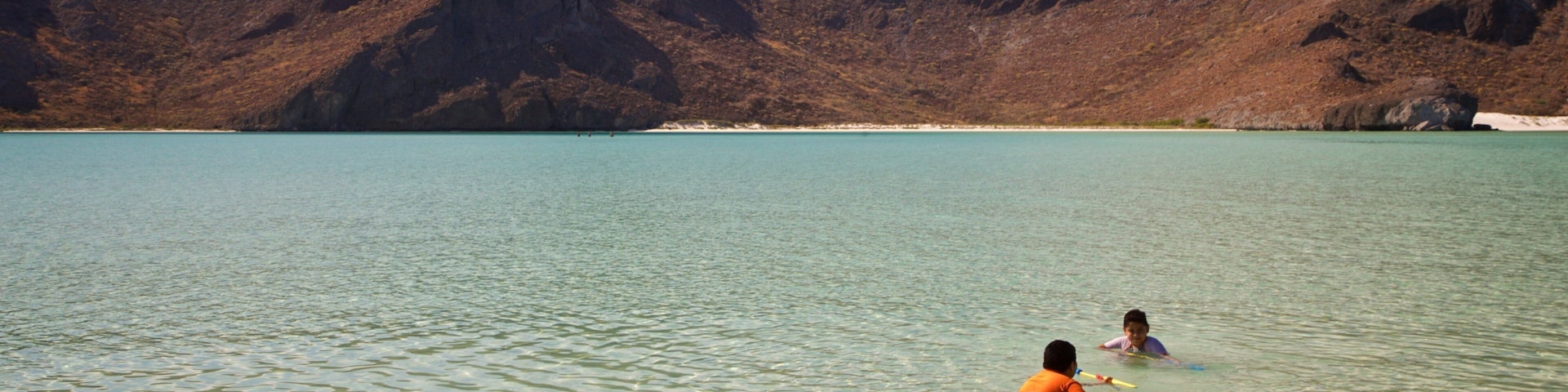 Balandra Beach featuring swimming and general coastal views as well as a small group of people